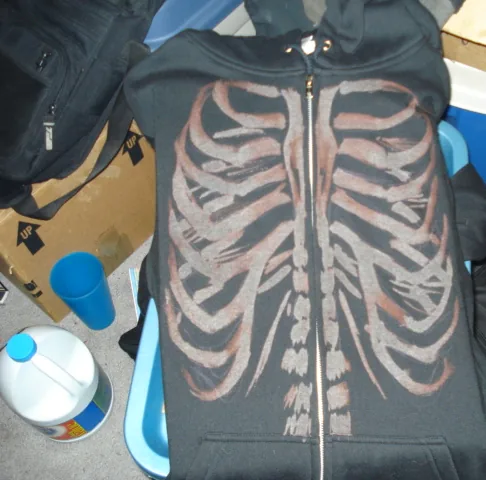 Black zip hoodie painted with a rib cage and spine