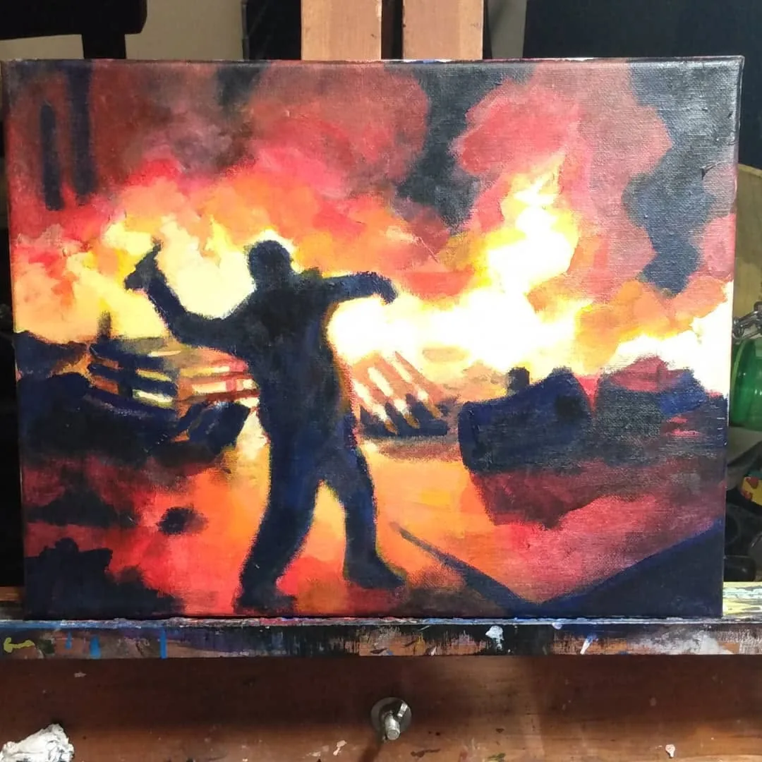 Silhouette throwing a Molotov cocktail before burning cars