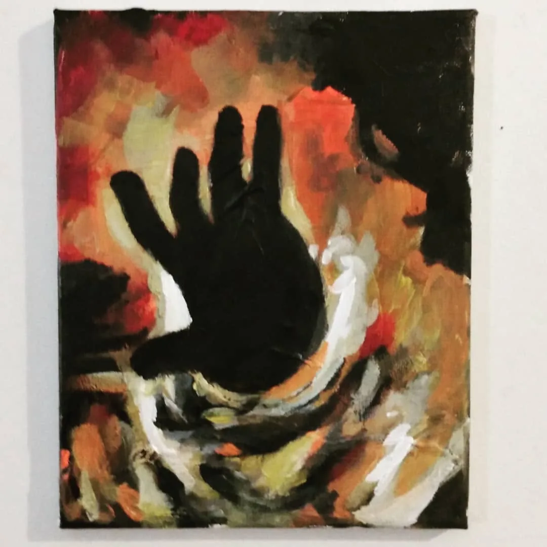 Dark hand silhouette held against rising flames