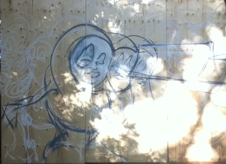Outline draft sprayed on the wood mural panel in daylight