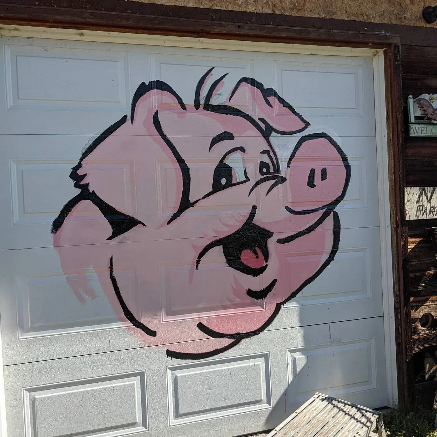 Finished cartoon pig mural painted on the Hog Saloon garage door