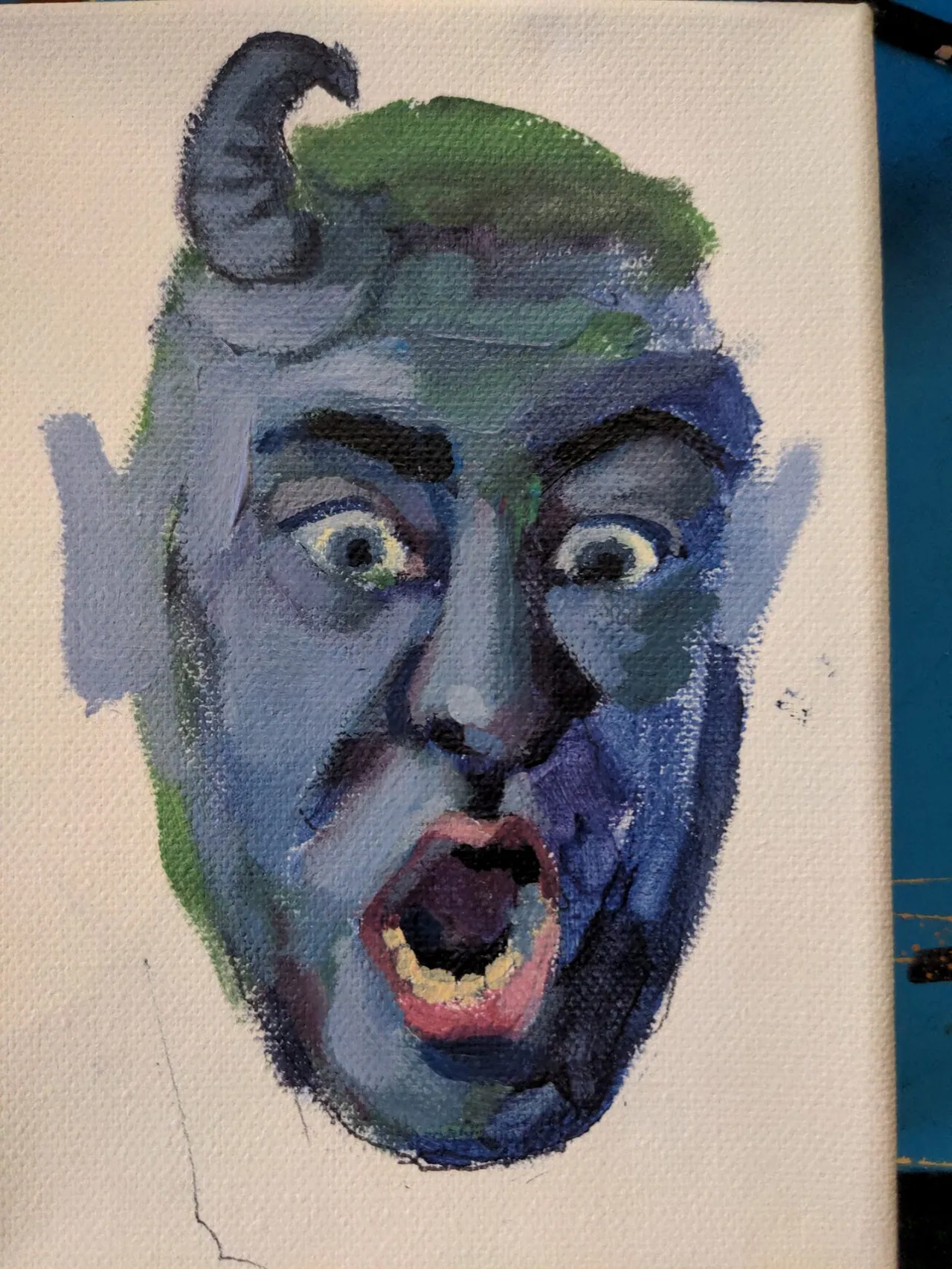 Expressive blue and green painted face study with an open mouth